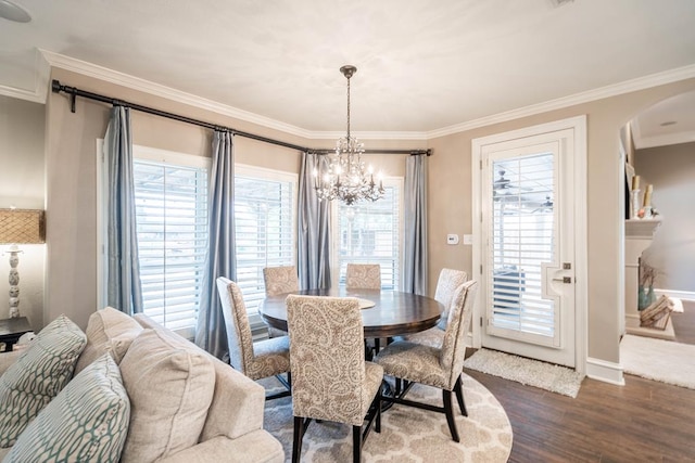 4508 Island Dr, Midland, TX 79707 - dining room with a chandelier, arched walkways, crown molding, dark wood finished floors, and baseboards