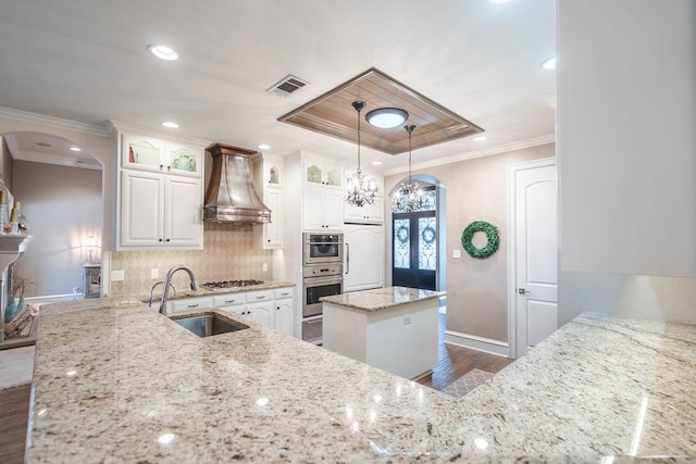 4508 Island Dr, Midland, TX 79707 - kitchen featuring a sink, custom range hood, arched walkways, baseboards, and crown molding