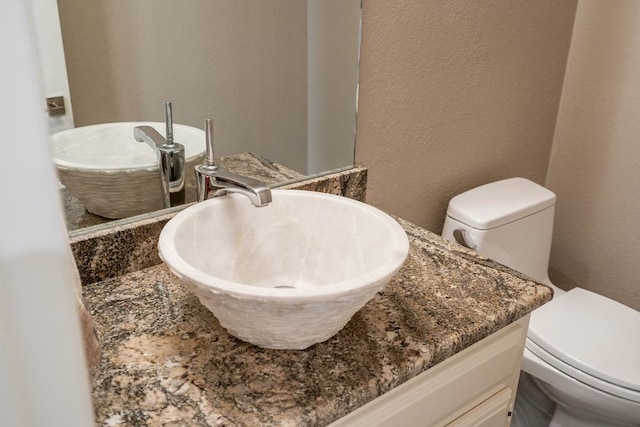 4508 Island Dr, Midland, TX 79707 - bathroom with toilet, a textured wall, and vanity