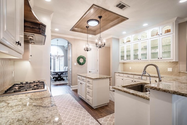 4508 Island Dr, Midland, TX 79707 - kitchen featuring a chandelier, custom range hood, stainless steel gas stovetop, dark wood-style floors, and arched walkways