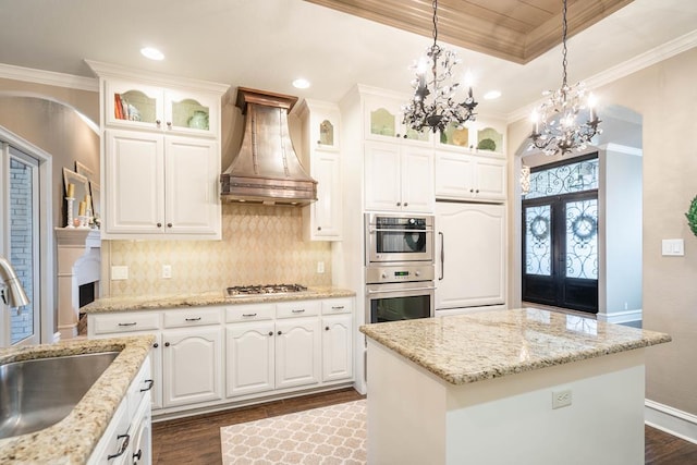 4508 Island Dr, Midland, TX 79707 - kitchen featuring wall chimney range hood, a sink, a chandelier, white gas stovetop, and crown molding