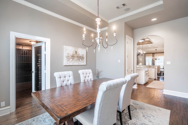 4508 Island Dr, Midland, TX 79707 - dining space with a chandelier, arched walkways, ornamental molding, dark wood-style floors, and baseboards