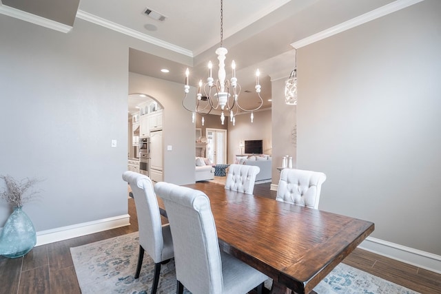 4508 Island Dr, Midland, TX 79707 - dining space with arched walkways, baseboards, a chandelier, crown molding, and wood finished floors