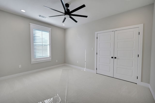 unfurnished bedroom featuring light carpet, ceiling fan, and a closet