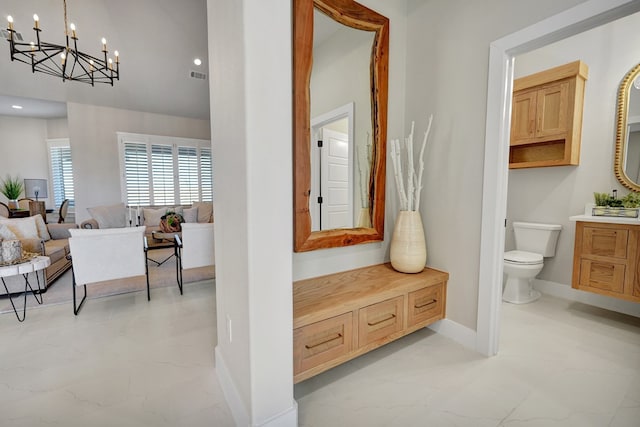 bathroom with vanity, a chandelier, and toilet