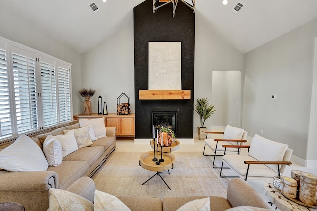 living room with a fireplace and high vaulted ceiling