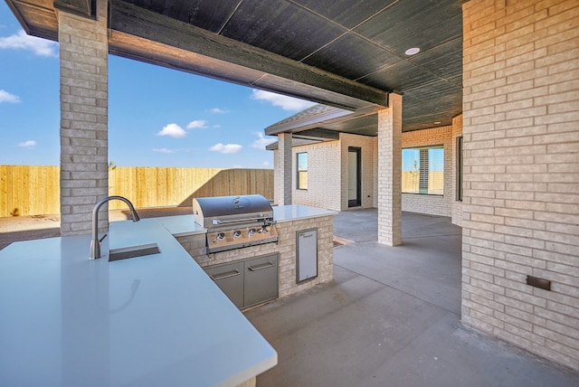 view of patio with an outdoor kitchen, sink, and grilling area