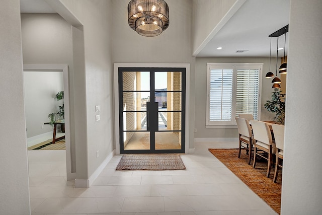 foyer entrance with a notable chandelier and french doors