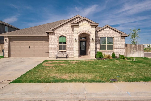 9 Senita Ct, Odessa, TX 79765 - french country home with brick siding, an attached garage, driveway, and roof with shingles