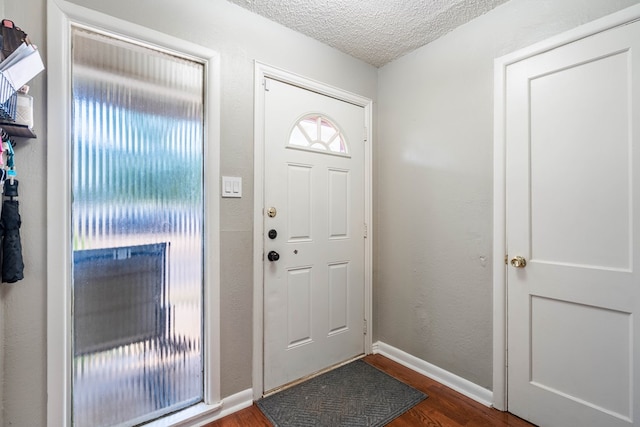 807 Boyd Ave, Midland, TX 79705 - foyer entrance featuring a textured ceiling, baseboards, and dark wood-type flooring