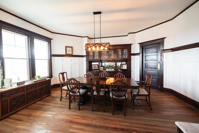 2306 32nd St, Snyder, TX 79549 - dining area with an inviting chandelier, dark wood-type flooring, and ornamental molding