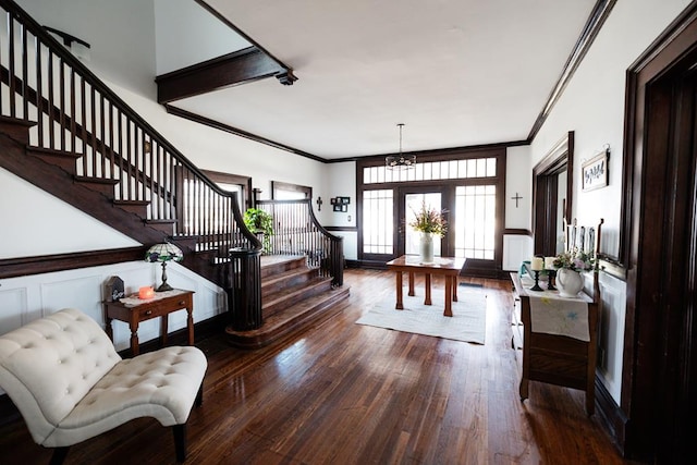 entrance foyer featuring a chandelier, wood-type flooring, and ornamental molding