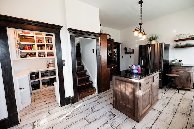 2306 32nd St, Snyder, TX 79549 - kitchen with stainless steel fridge, pendant lighting, a kitchen island, and light hardwood / wood-style floors