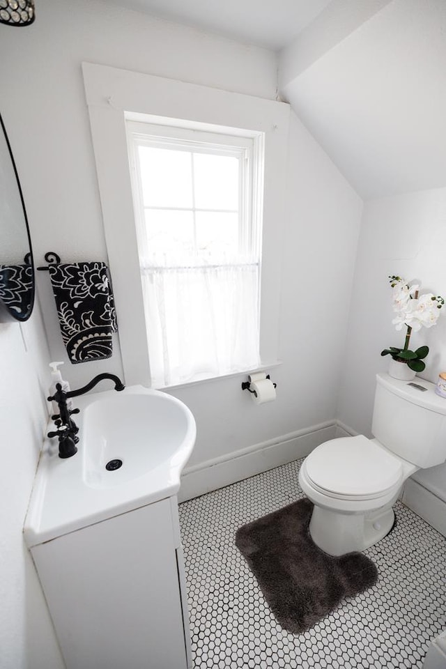2306 32nd St, Snyder, TX 79549 - bathroom with tile patterned flooring, vanity, toilet, and lofted ceiling