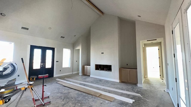 unfurnished living room featuring beamed ceiling and high vaulted ceiling