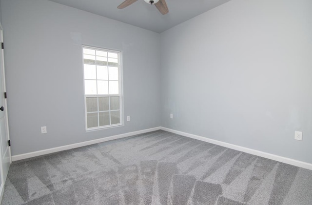 carpeted spare room featuring ceiling fan