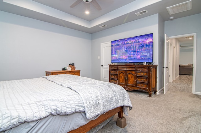 carpeted bedroom featuring ceiling fan and a raised ceiling