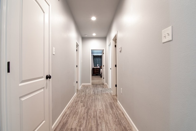 corridor with light hardwood / wood-style floors