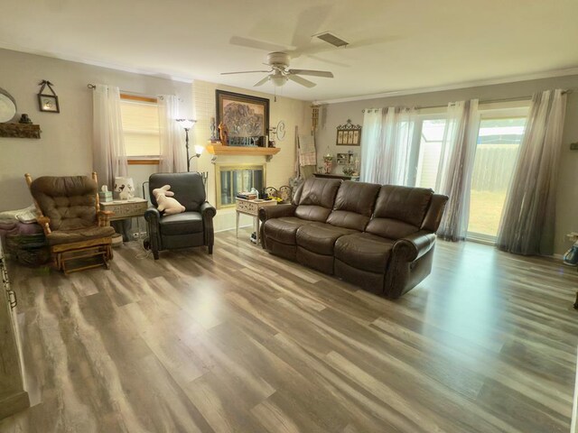 311 Kessler Ave, Midland, TX 79701 - living room with wood finished floors, a ceiling fan, ornamental molding, and a large fireplace