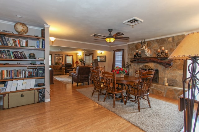 dining space with visible vents, ornamental molding, a ceiling fan, and wood finished floors