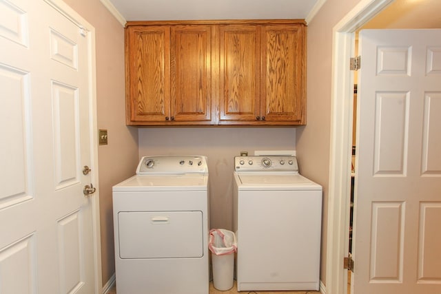 clothes washing area with independent washer and dryer and cabinet space
