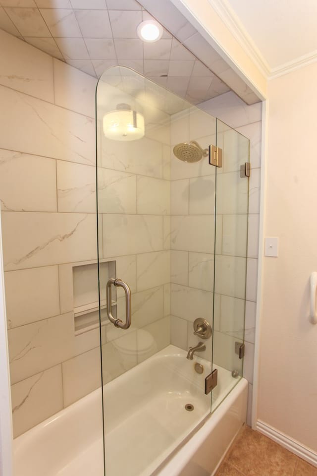 full bath featuring shower / bath combination with glass door, baseboards, ornamental molding, and tile patterned floors