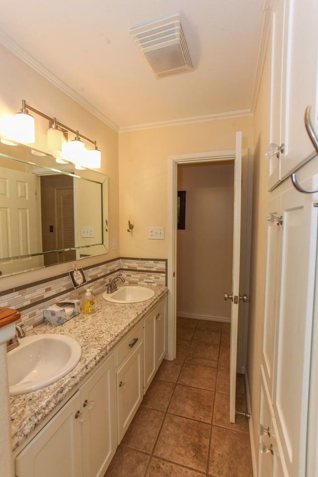 bathroom featuring a sink, ornamental molding, tasteful backsplash, and visible vents