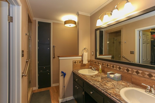 bathroom with double vanity, tiled shower, a sink, and tasteful backsplash
