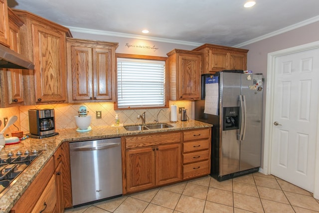 kitchen with a sink, appliances with stainless steel finishes, tasteful backsplash, and brown cabinets