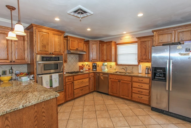 kitchen featuring a sink, appliances with stainless steel finishes, brown cabinetry, and under cabinet range hood