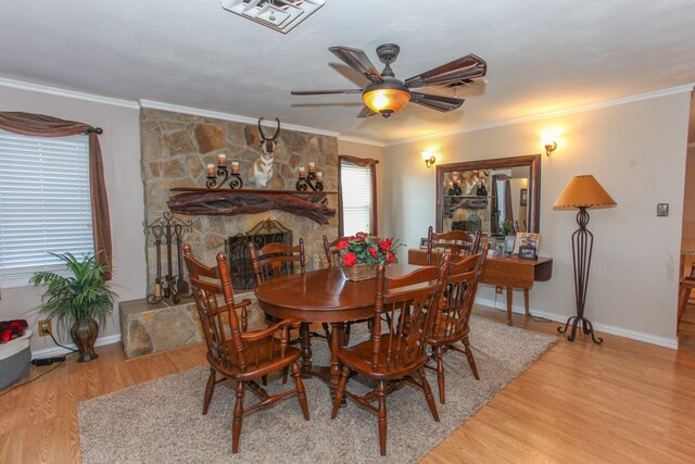 dining room featuring baseboards, ornamental molding, a ceiling fan, and wood finished floors