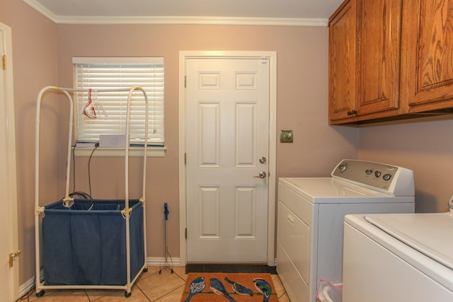 washroom with crown molding, washing machine and dryer, baseboards, cabinet space, and light tile patterned floors