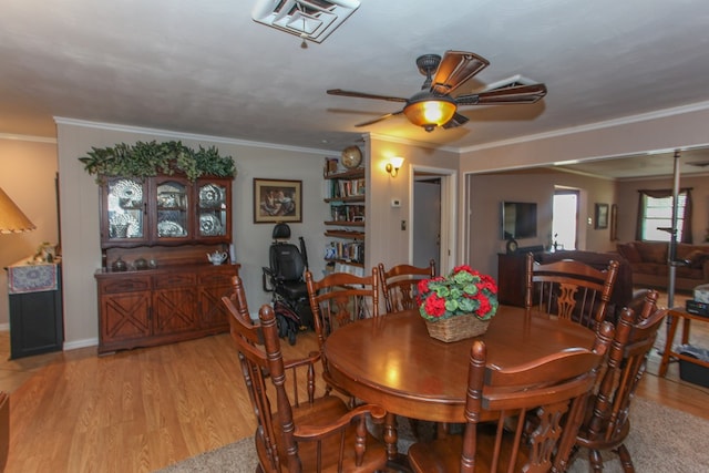 dining space featuring ceiling fan, ornamental molding, light wood-style flooring, and visible vents