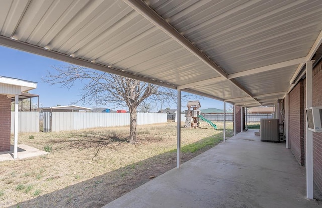 view of patio / terrace featuring cooling unit, a playground, and a fenced backyard