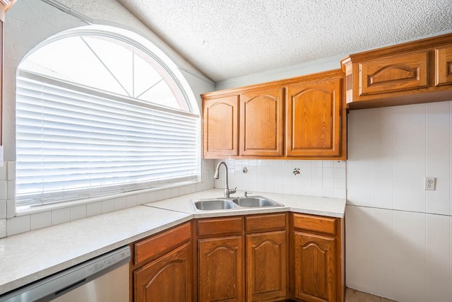kitchen with a textured ceiling, light countertops, dishwasher, a sink, and backsplash