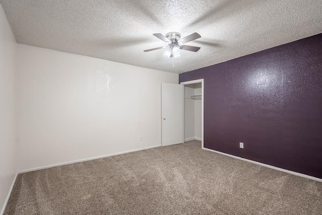 unfurnished bedroom with a closet, carpet floors, a textured ceiling, baseboards, and ceiling fan