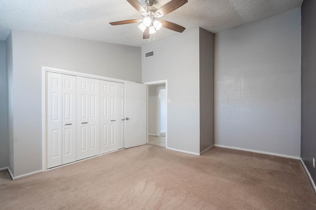 unfurnished bedroom featuring a closet, a textured ceiling, visible vents, and carpet