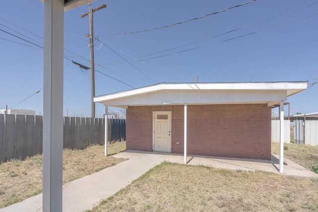 exterior space with fence and brick siding