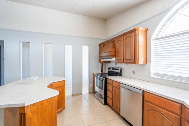 kitchen featuring backsplash, light countertops, stainless steel appliances, and a center island