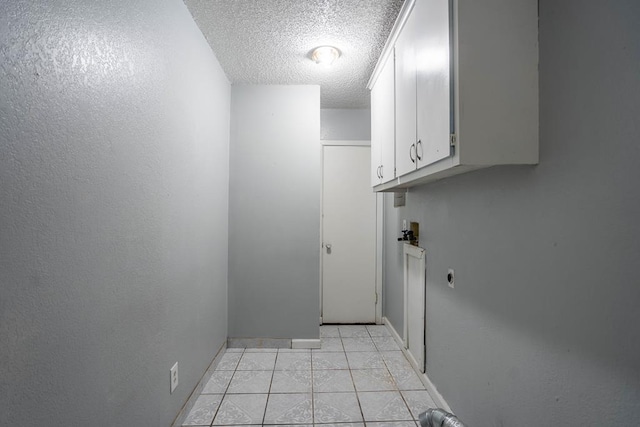 clothes washing area featuring hookup for a washing machine, a textured ceiling, light tile patterned flooring, cabinet space, and electric dryer hookup