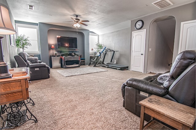 carpeted living room with ceiling fan, a textured ceiling, and lofted ceiling