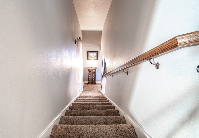 stairs with a textured ceiling