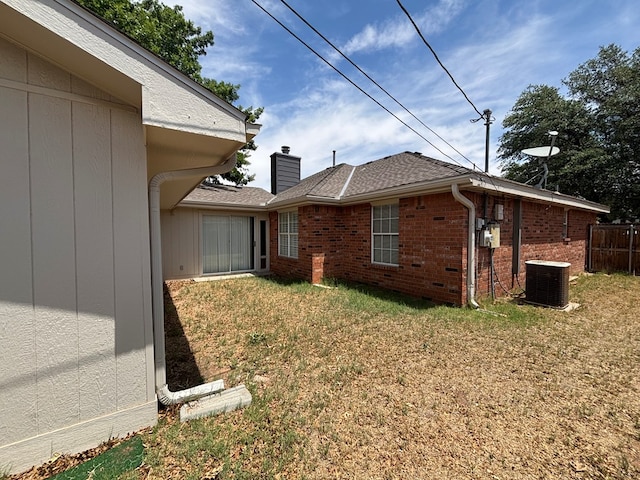 3507 Edgemont Dr, Midland, TX 79707 - view of side of home featuring cooling unit, brick siding, and a chimney