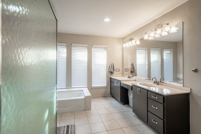 bathroom with double vanity, tile patterned flooring, a sink, and a bath