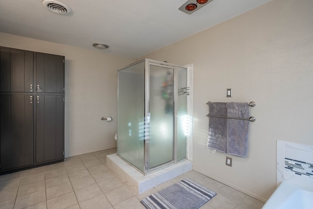 full bathroom with a stall shower, a washtub, visible vents, and tile patterned floors