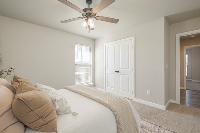 carpeted bedroom with ceiling fan and a closet