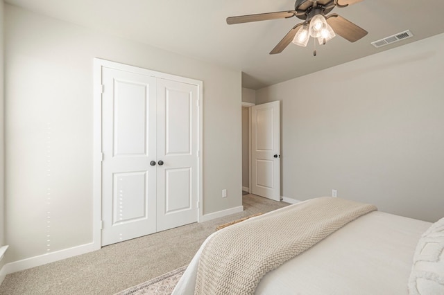 bedroom with light carpet, ceiling fan, and a closet