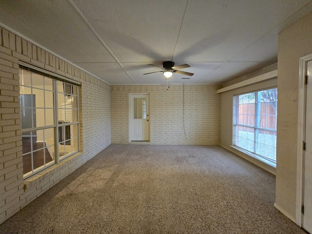 4908 Timber Ct, Midland, TX 79707 - unfurnished room featuring brick wall, carpet, and a ceiling fan