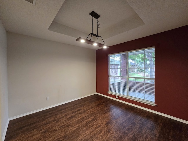 4908 Timber Ct, Midland, TX 79707 - unfurnished room featuring dark wood-type flooring, a raised ceiling, baseboards, and a textured ceiling