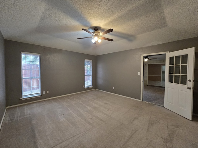 4908 Timber Ct, Midland, TX 79707 - carpeted empty room featuring a ceiling fan, a textured ceiling, plenty of natural light, and baseboards